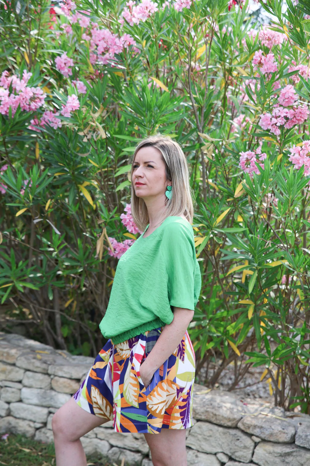 short fleuri de profil avec haut vert main dans la poche